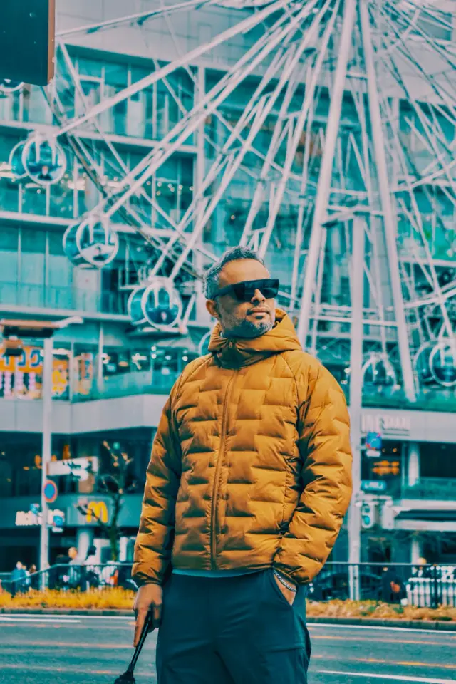A portrait in front of a ferris wheel