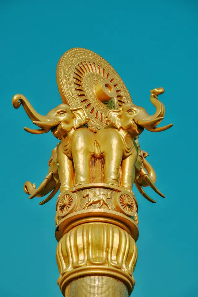 A golden elephant finial against a blue sky