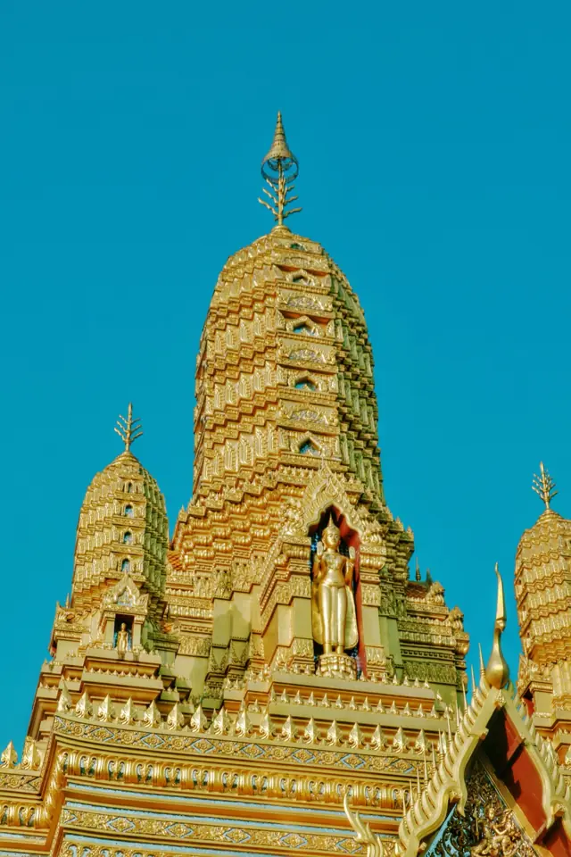 A golden temple tower against a blue sky