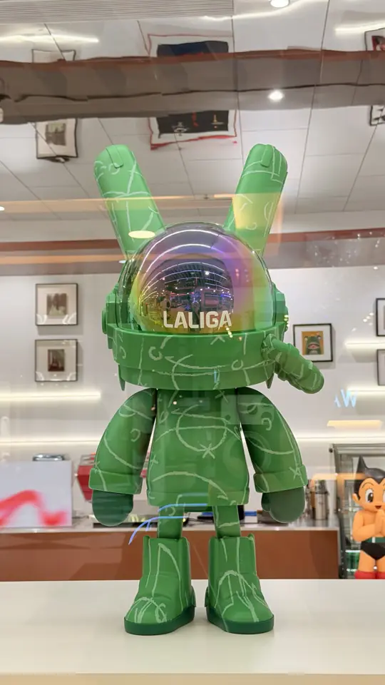 A green collectible figure in a glass case