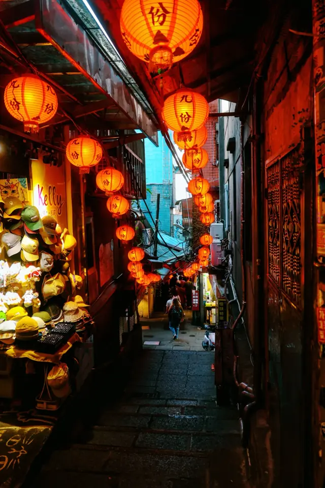 A narrow alley lit by red lanterns