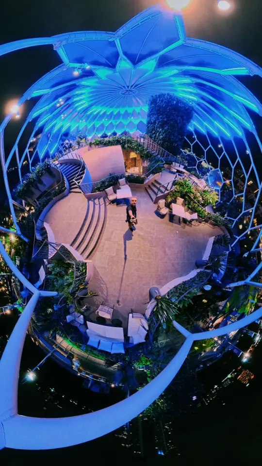 A tiny-planet panorama of a glowing blue dome garden